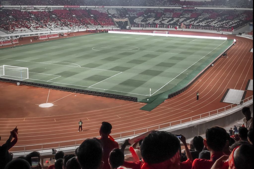 stadium stand over looking a football pitch and athletics track